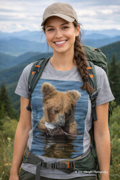 Insert this image onto the t-shirt of an attractive young woman wearing hiking clothes standing with a mountain landscape behind her but woman is facing viewer and smiling